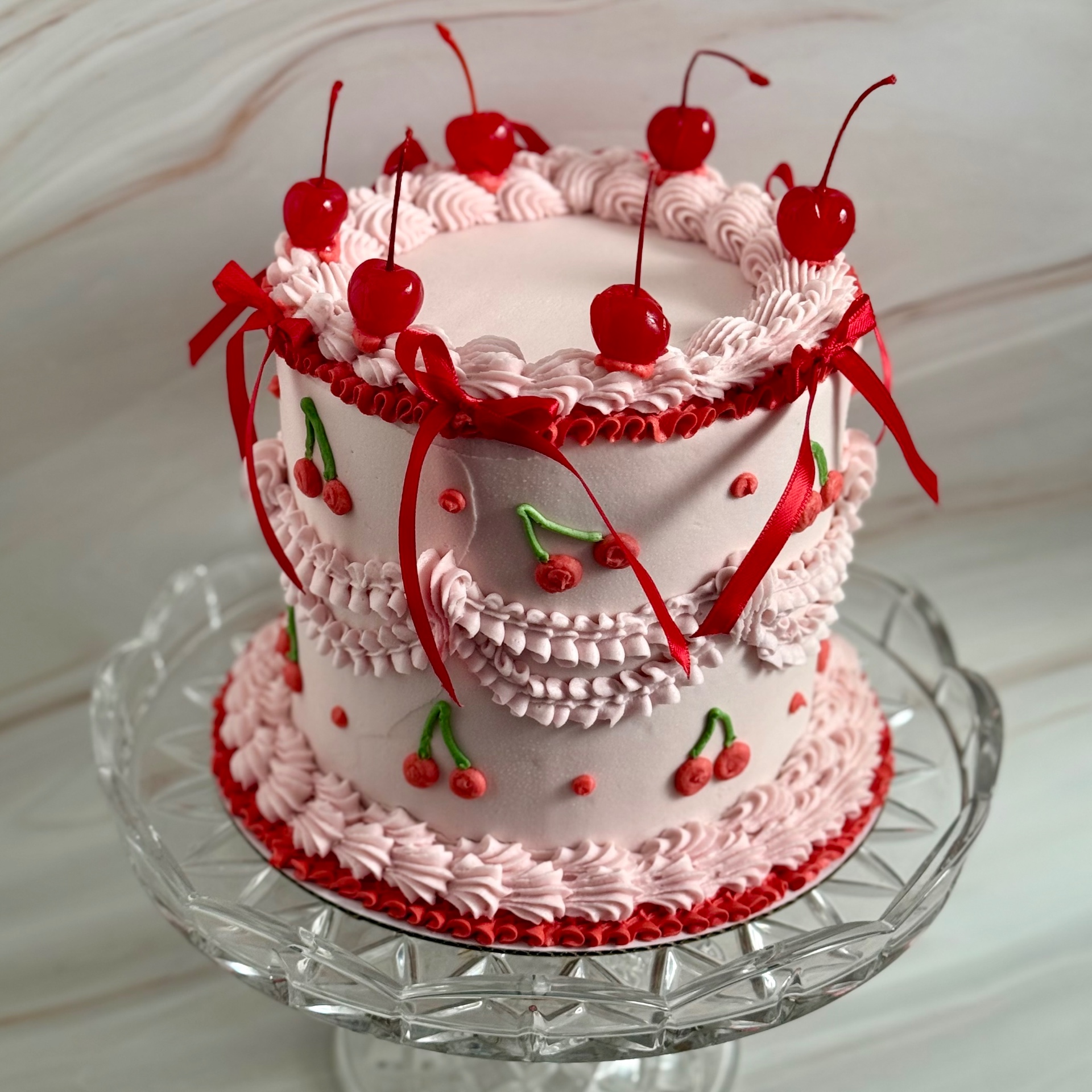 Pink cherry-topped celebration cake from Goldie's Baking Co.